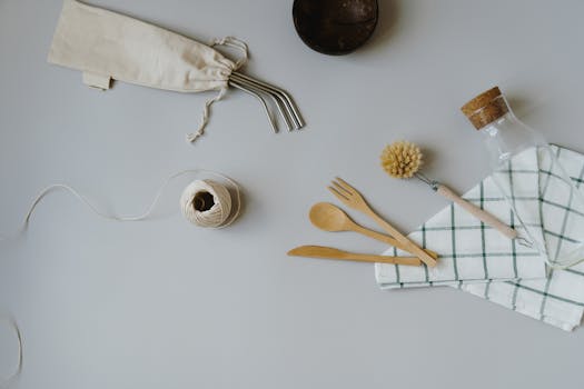 Ustensiles de cuisine en bois, pailles réutilisables et accessoires zéro déchet sur une table en bois.